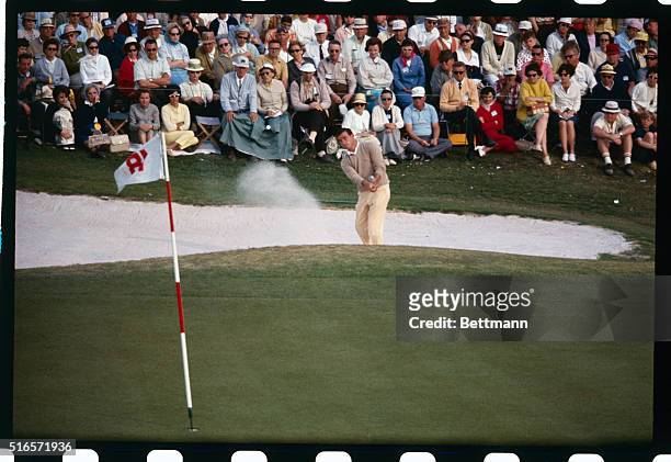 Randy Glover blasts out of the sand trap and putts on 18th green during the third round of the Masters Golf Tournament.