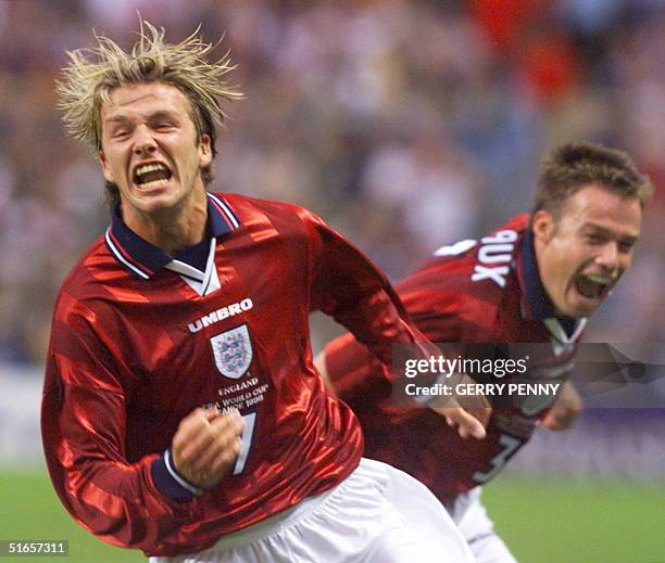 English midfielder David Beckham jubilates after he scored the second goal of his team, next to teammate Graeme Le Saux 26 June at the Felix Bollaert...