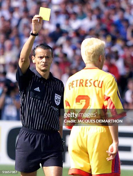 Argentinian referee Javier Alberto Castrilli holds up a yellow card for Romanian defender Dan Petrescu 30 June at the Parc Lescure in Bordeaux during...