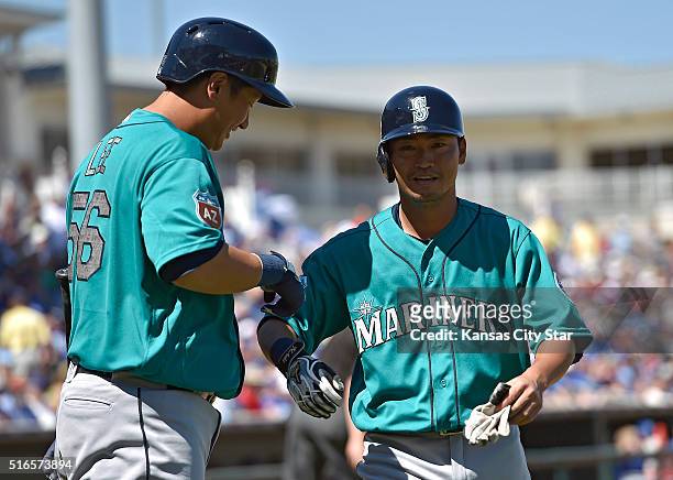 The Seattle Mariners' Nori Aoki, right, is greeted by Dae Ho Lee after scoring on a single by Kyle Seager in the first inning against the Kansas City...