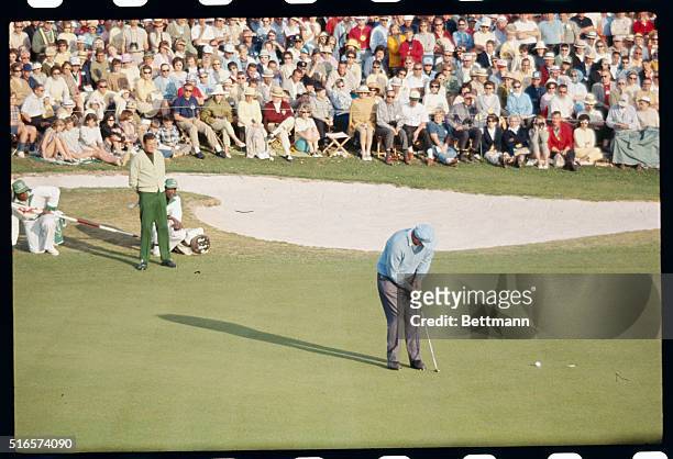 Doug Sanders watches peter Butler putting on the 18th green during April 9th third round of play in the masters Golf tournament.