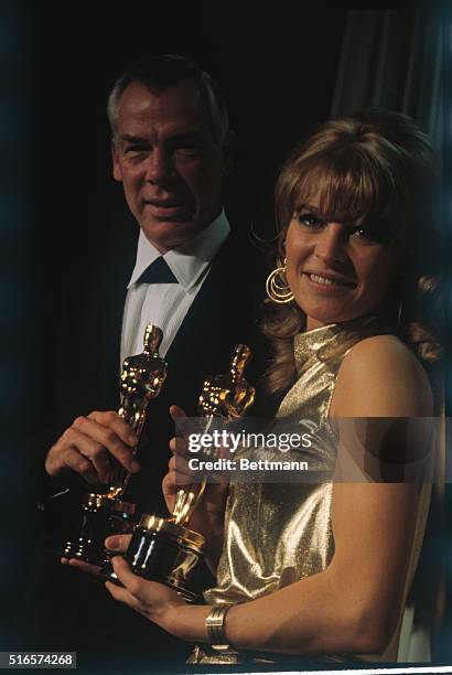 Lee Marvin and Julie Christie hold the Oscars presented to them, at the Academy Awards presentation ceremonies. Marvin was named Best Actor for his...