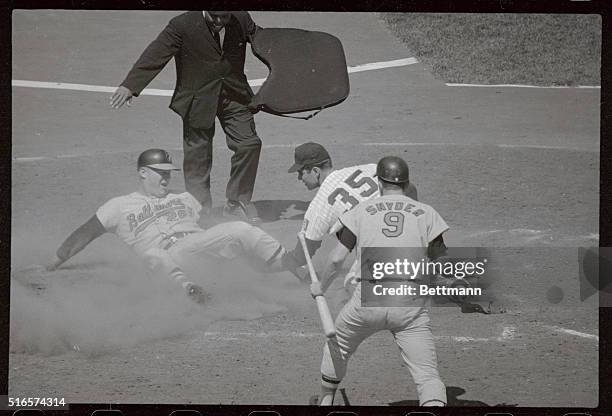 John Powell, of the Baltimore Orioles is safe at home after Minnesota Twin's pitcher Pete Cimino, lost hold of the throw from catcher Earl Battey,...