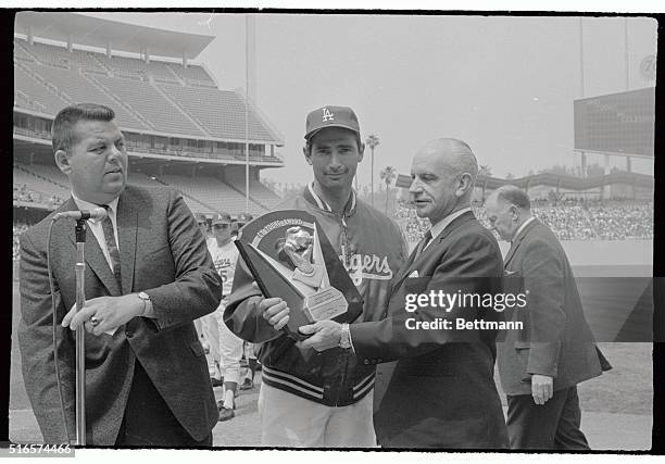 Dodgers' Sandy Koufax is presented the Cy Young Award plaque by Commissioner of baseball, Gen. William B. Eckert, pitching during the 1965 baseball...