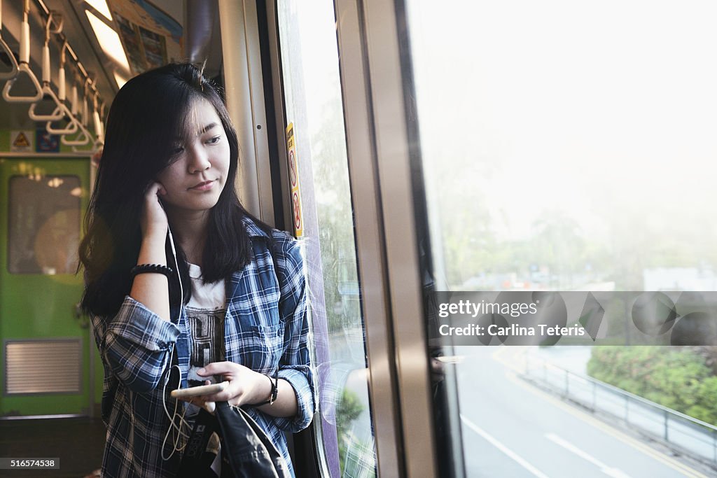 Woman in LRT looking out the window