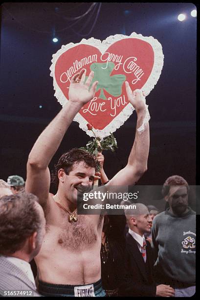 Boxer Gerry Norton holds up a heart tribute and shamrock after winning fight in first round against Ken Norton at New York's Madison Square Garden in...