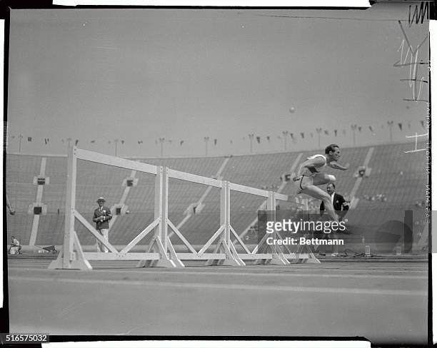 Erwin Wegner of Germany soars over the last hurdle with the rest of the field well behind during the 110 Meter hurdle event of the Decathlon at the...