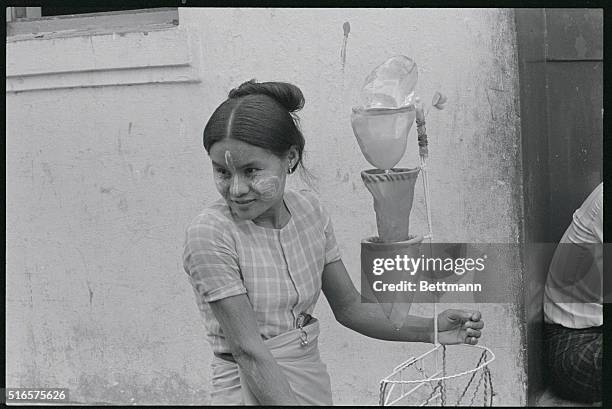 Rangoon: Street Scenes. Rangoon, Burma: What's this young woman doing? She's a water seller in Rangoon. Cold water is a luxury for people going...