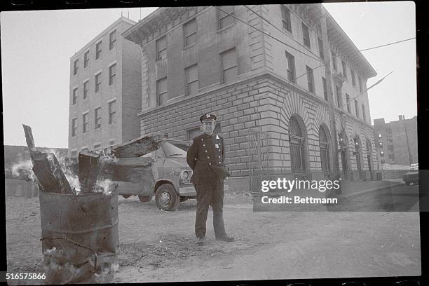 Fort Apache. New York: A policeman warms himself outside "Fort Apache," a police station house sitting at the center of what was once one of the...