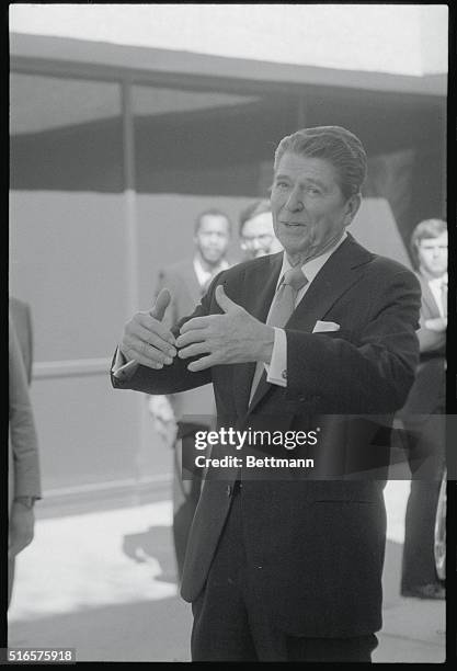 Washington, DC: President Reagan talks to reporters as he leaves Walter Reed Hospital March 12, after visiting ailing Senator Robert Dole, R-Kansas....
