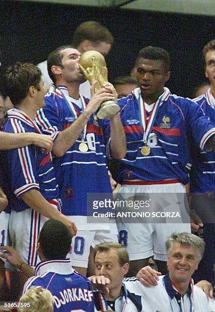 French Zinedine Zidane kisses the FIFA Trophy 12 July at the Stade de France in Saint-Denis, after the 1998 World Cup final match pitting Brazil...