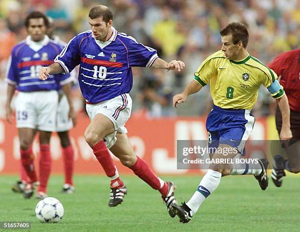 French playmaker Zinedine Zidane dribbles by Brazilian captain Dunga 12 July at the Stade de France in Saint-Denis, during he 1998 World Cup final...