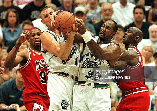 Greg Ostertag and Karl Malone of the Utah Jazz fight for a loose ball with Dennis Rodman and Michael Jordan of the Chicago Bulls 08 June during game...