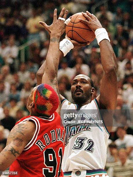 Karl Malone of the Utah Jazz shoots over Dennis Rodman of the Chicago Bulls 08 June during game four of the 1997 NBA Finals at the Delta Center in...