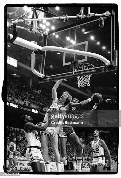 Lakers' Kareem Abdul-Jabbar fakes out Celtics' Larry Bird as he goes up for two points during second quarter action at Boston garden, 1/18. At right...