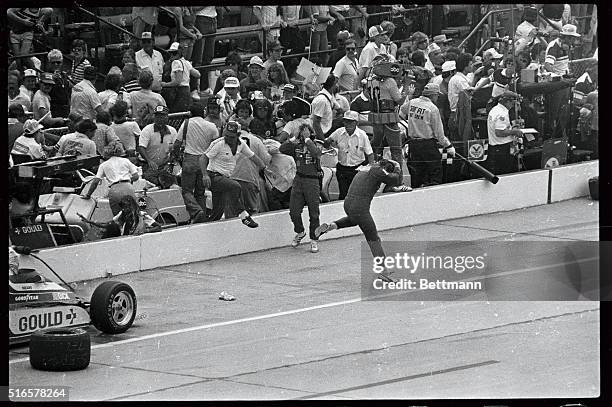 Rick Mears jumps from his car as it is enveloped in white-hot flames in the pits during the Indy 500. Mear's wife, Dina Lynn is held back by crew...