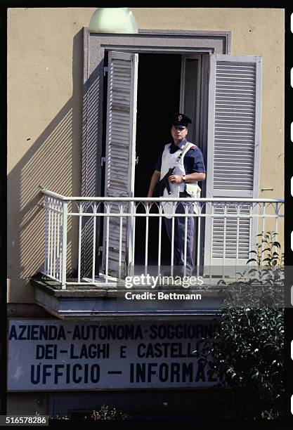 Wearing a bullet-proof vest, a policeman holding his submachine gun stands on a terrace of an apartment in the main square of Castel Gandolfo, next...