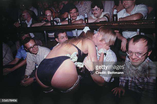 Club dancer at Chippendales in Los Angeles, Staci Stearns, kisses a customer before her mudwrestling act begins.