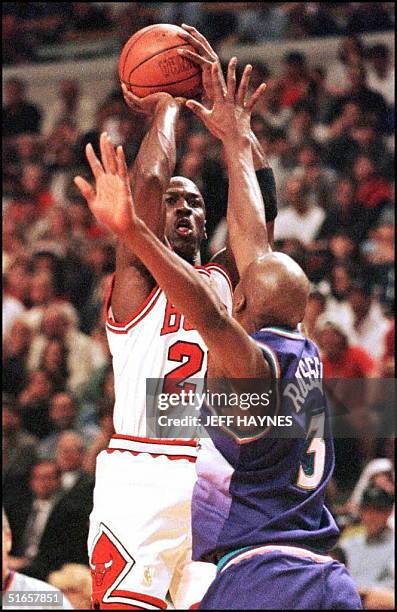 Michael Jordan of the Chicago Bulls shoots over Bryon Russell of the Utah Jazz 13 June during the first half of game six of the 1997 NBA Finals at...