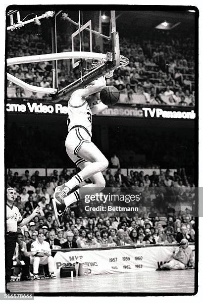 Referee Earl Strom gives the "two-points" signal as the Celtics' Larry Bird stuffs the basket in third quarter action of the first game of the Best...