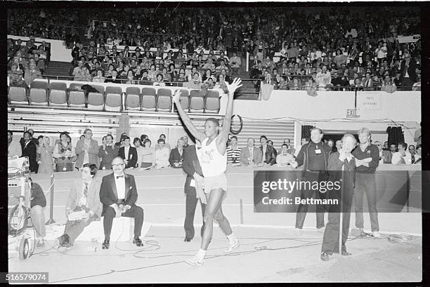 Carl Lewis, representing Santa Monica Track Club, jubilates as officials measure his world indoor record in the long jump at Millrose Games. Jump...