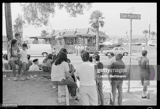 Crowd of people watches the scene outside the McDonald's restaurant in which a lone gunman killed 20 people in San Ysidro, California.