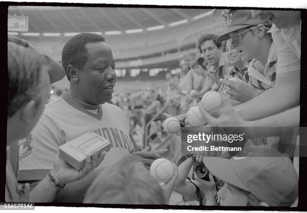 National League Baseball great Hank Aaron is surrounded by baseball fans that want his autograph prior to the start of the third annual Cracker Jack...