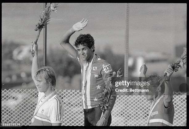 Alex Grewal, USA cyclist, and Gold Medal winner in the 190.2KM cycling race, is joined on the victory stand by Canada's Steve Bauer, , and Norway's...