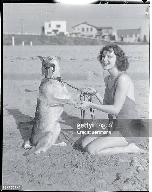 Near Hollywood: A Lucky Pet. Most any dog would be willing to sit up and do tricks for pretty Frances Dee, Paramount player, who's having some fun...