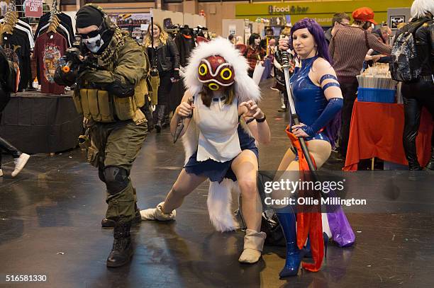 Atendees at Comic Con 2016 in cosplay as a Call of Duty multiplayer, Princess Mononoke and Katana on March 19, 2016 in Birmingham, United Kingdom.