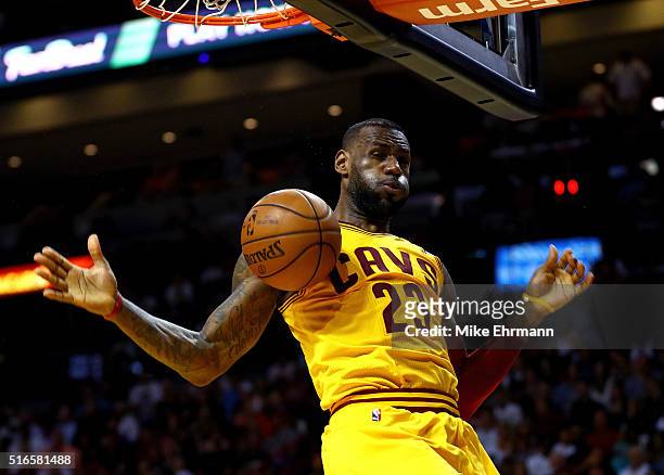 LeBron James of the Cleveland Cavaliers dunks during a game against the Miami Heat at American Airlines Arena on March 19, 2016 in Miami, Florida....