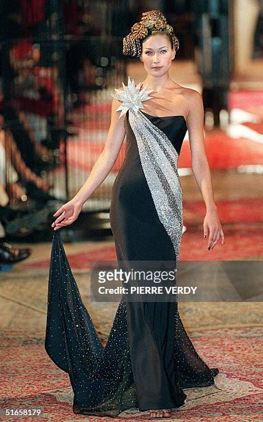 Italian top model Carla Bruni harkens back to the Audrey Hepburn era in this long black and silver evening dress, presented by British designer...