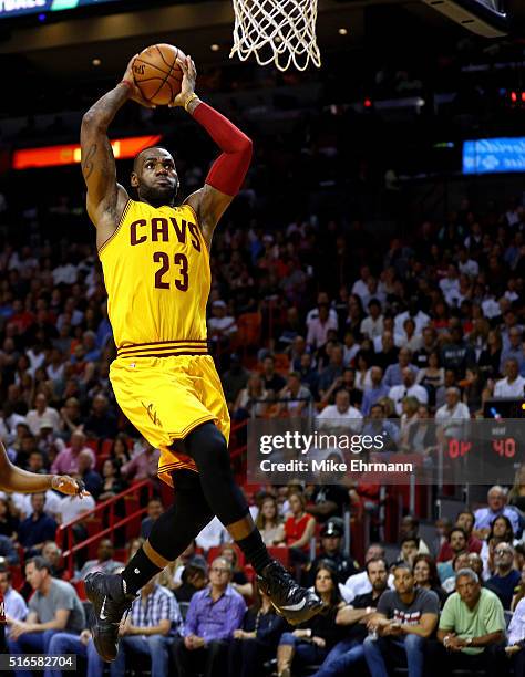 LeBron James of the Cleveland Cavaliers dunks during a game against the Miami Heat at American Airlines Arena on March 19, 2016 in Miami, Florida....