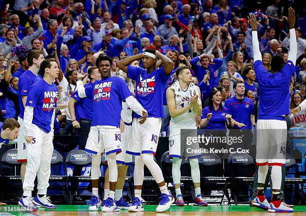 The bench reacts after Wayne Selden Jr. #1 of the Kansas Jayhawks dunked against the Connecticut Huskies in the second half during the second round...
