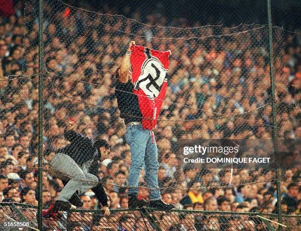 Soccer supporter attaches a Nazi flag to a crowd barrier during a Spanish first division match between Real Madrid and Barcelona in Bernabeu stadium...