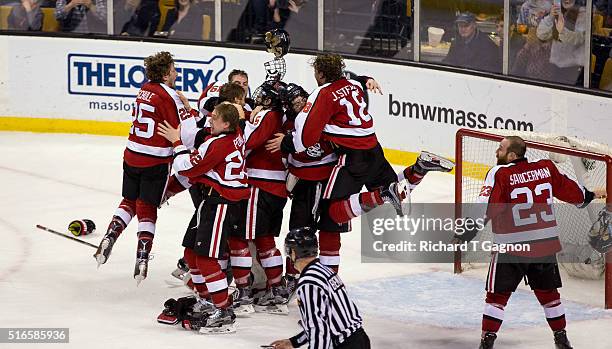 Tanner Pond and John Stevens of the Northeastern Huskies jumps on his teammates Zach Aston-Reese, Nolan Stevens, Matt Benning and Ryan Ruck after...