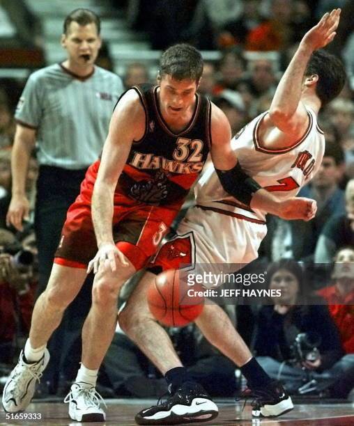 Toni Kukoc of the Chicago Bulls takes the charge from Christian Laettner of the Atlanta Hawks 08 May during the first half of game two of their...