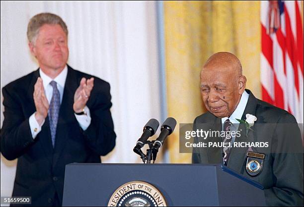 Ninety-four-year-old Herman Shaw speaks as US President Bill Clinton looks on during ceremonies at the White House in Washington 16 May in which...