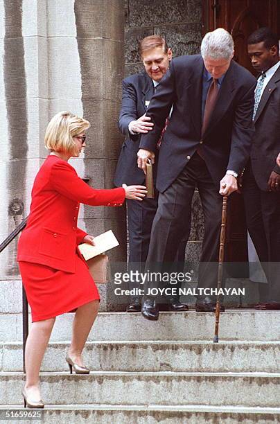 First Lady Hillary Clinton helps President Bill Clinton walk down the steps at the Foundry Methodist Church after Sunday services 25 May in...