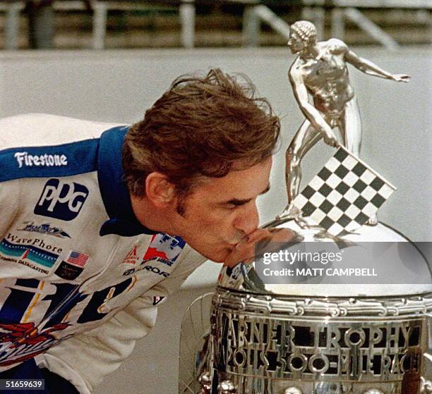 Indianapolis 500 winner for 1997, Arie Luyendyk of Holland, kisses the Borg-Warner trophy after the official winner's photo 28 May at the...