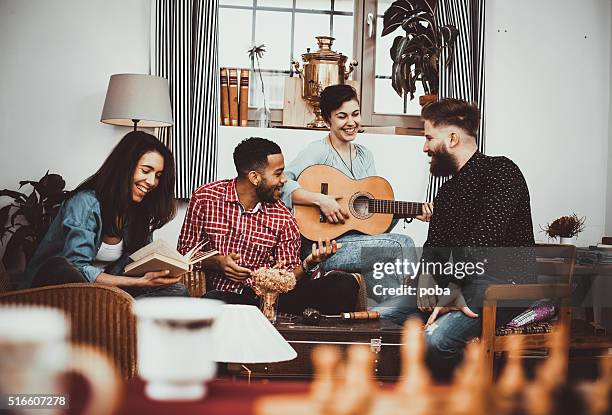 feliz grupo de amigos canta y tocando música juntos - party friends home guitar singers fotografías e imágenes de stock