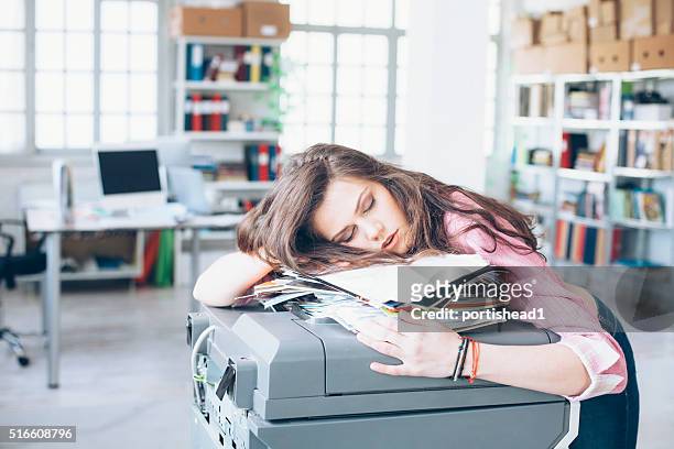 junge frau schlafen im büro - indecisive stock-fotos und bilder