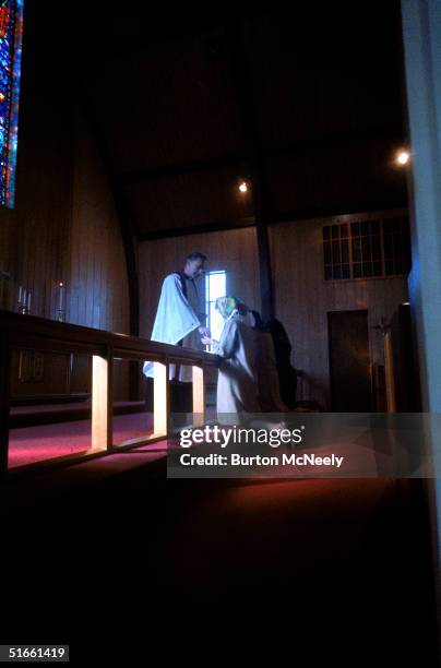 Marilyn Lovell kneels as she receives communion from Father Donald Raish on the day of her astronaut husband's first space flight as part of the...