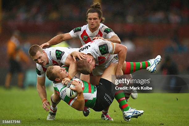 Ben Creagh and Michael Cooper of the Dragons tackle Jason Clark of the Rabbitohs during the round three NRL match between the St George Dragons and...