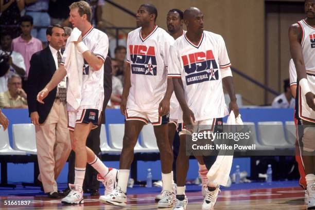 Larry Bird, Earvin Johnson, Michael Jordan and Karl Malone of the USA Olympic Basketball Team walk on the court during a game against The Republic of...