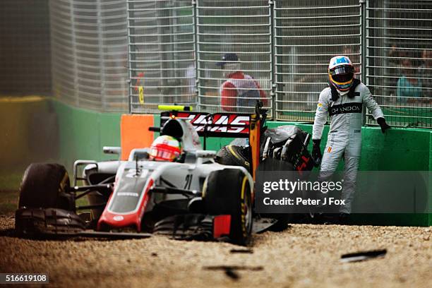 Fernando Alonso of Spain and McLaren Honda climbs out of his car after crashing Esteban Gutierrez of Mexico, Haas F1 Team Haas-Ferrari VF-16 Ferrari...