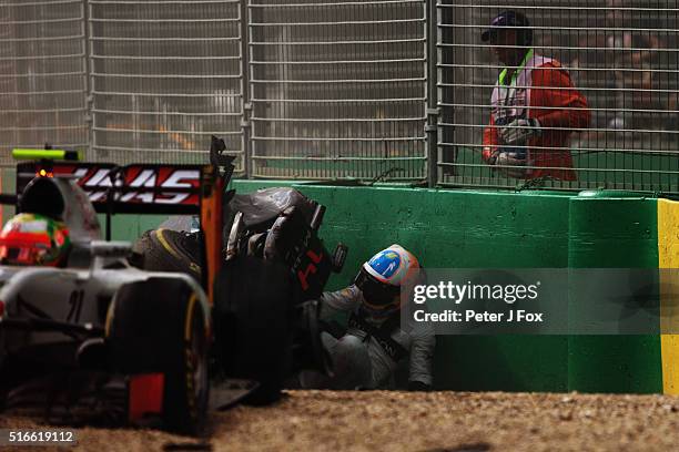 Fernando Alonso of Spain and McLaren Honda climbs out of his car after crashing Esteban Gutierrez of Mexico, Haas F1 Team Haas-Ferrari VF-16 Ferrari...