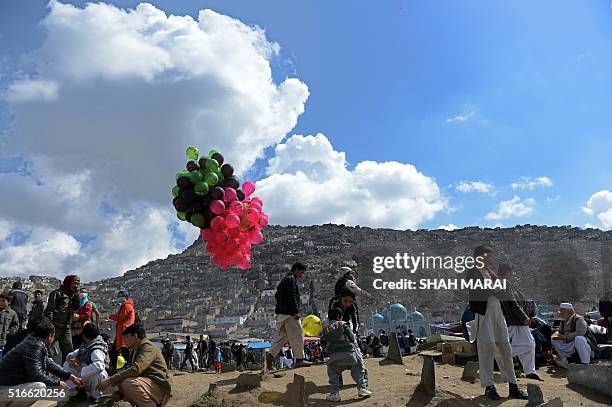 An Afghan vendor sells balloons in Kabul on March 20 for Nowruz festivities as devotees mark the Afghan New Year. Nowruz, one of the biggest...