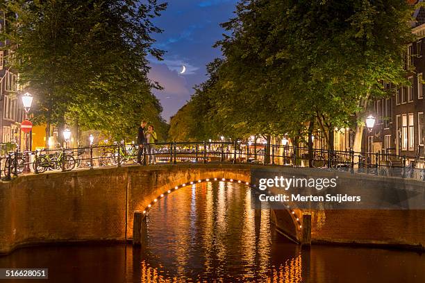 moon above romantic couple on amsterdam bridge - moonlight lovers stock pictures, royalty-free photos & images