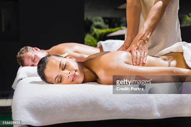 relaxed woman receiving back massage - マッサージ台 ストックフォトと画像